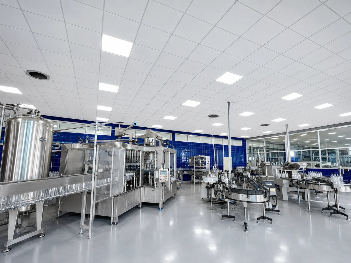 Sala de proceso con estanques de acero inoxidable y la llenadora en operación