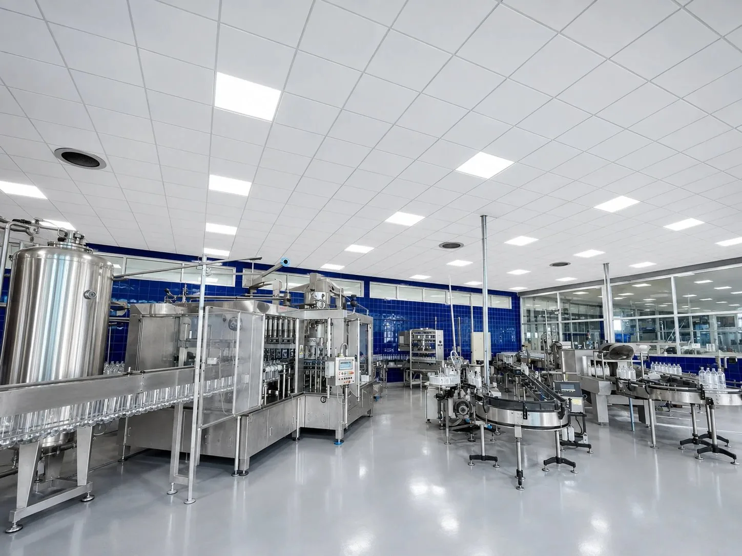 Sala de proceso con estanques de acero inoxidable y la llenadora en operación