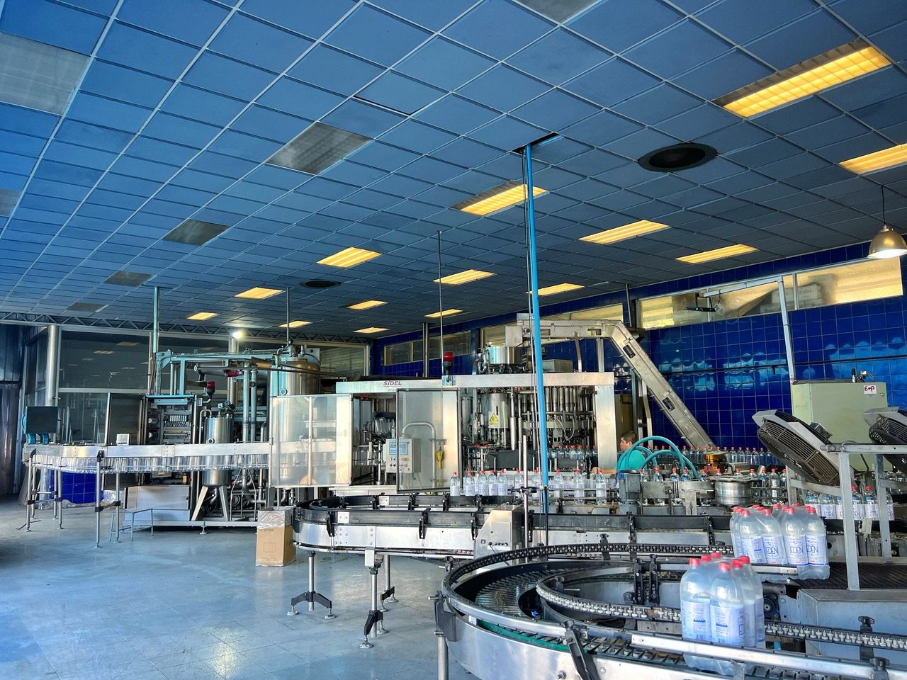 Línea de llenado y transportador de botellas en la planta embotelladora de Edén